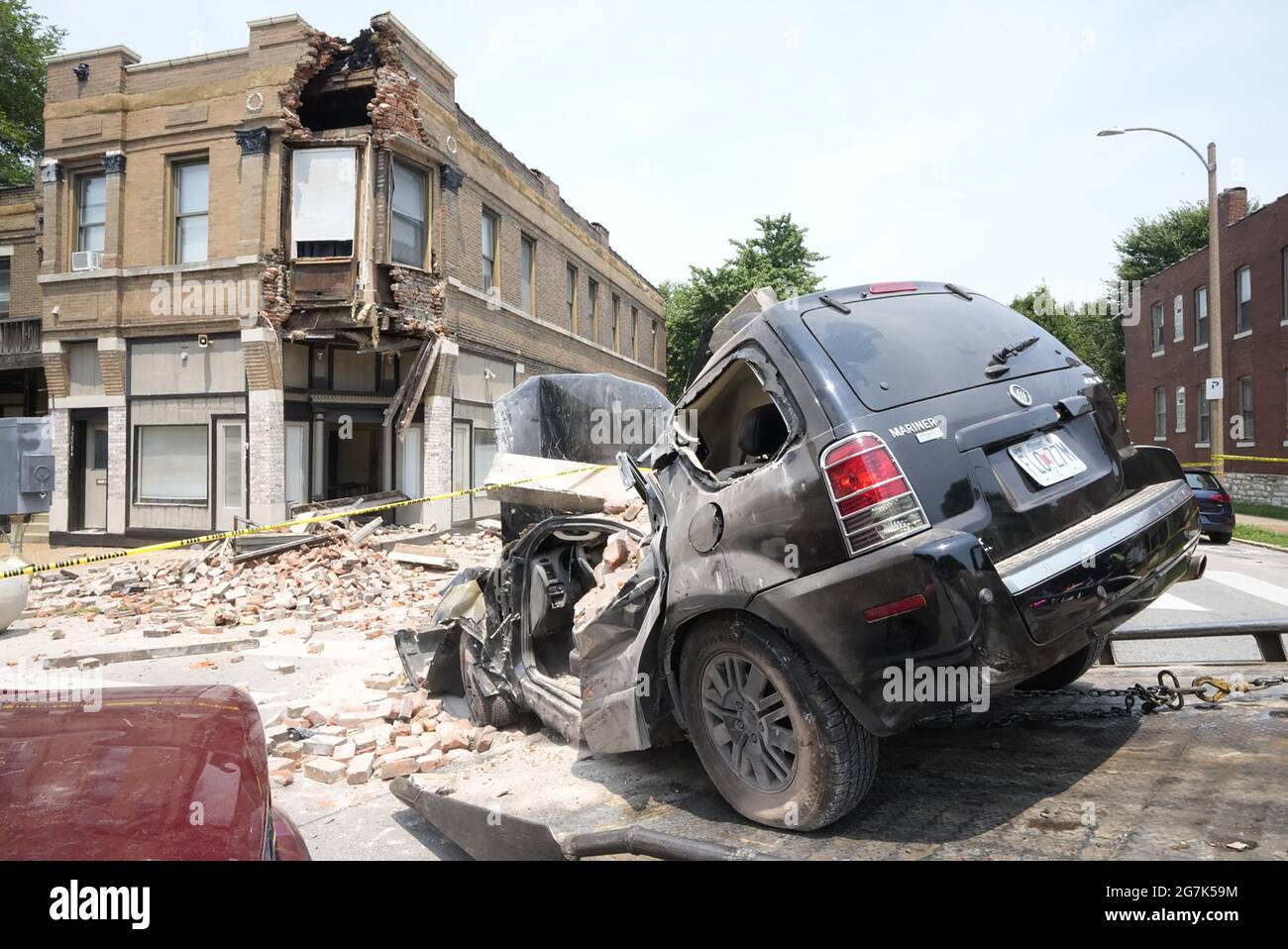 St. Louis, États-Unis. 14 juillet 2021. Une voiture est tirée sur un camion à plateau après être entrée dans un bâtiment à St. Louis le mercredi 14 juillet 2021. Selon des sources, le conducteur est entré en collision avec une autre voiture, s'est enlabouré dans le bâtiment puis s'est enfui lorsque des parties du bâtiment ont commencé à tomber sur la voiture. Les inspecteurs de la division du bâtiment ne savent pas si le bâtiment peut être sauvegardé. Photo par Bill Greenblatt/UPI crédit: UPI/Alay Live News Banque D'Images