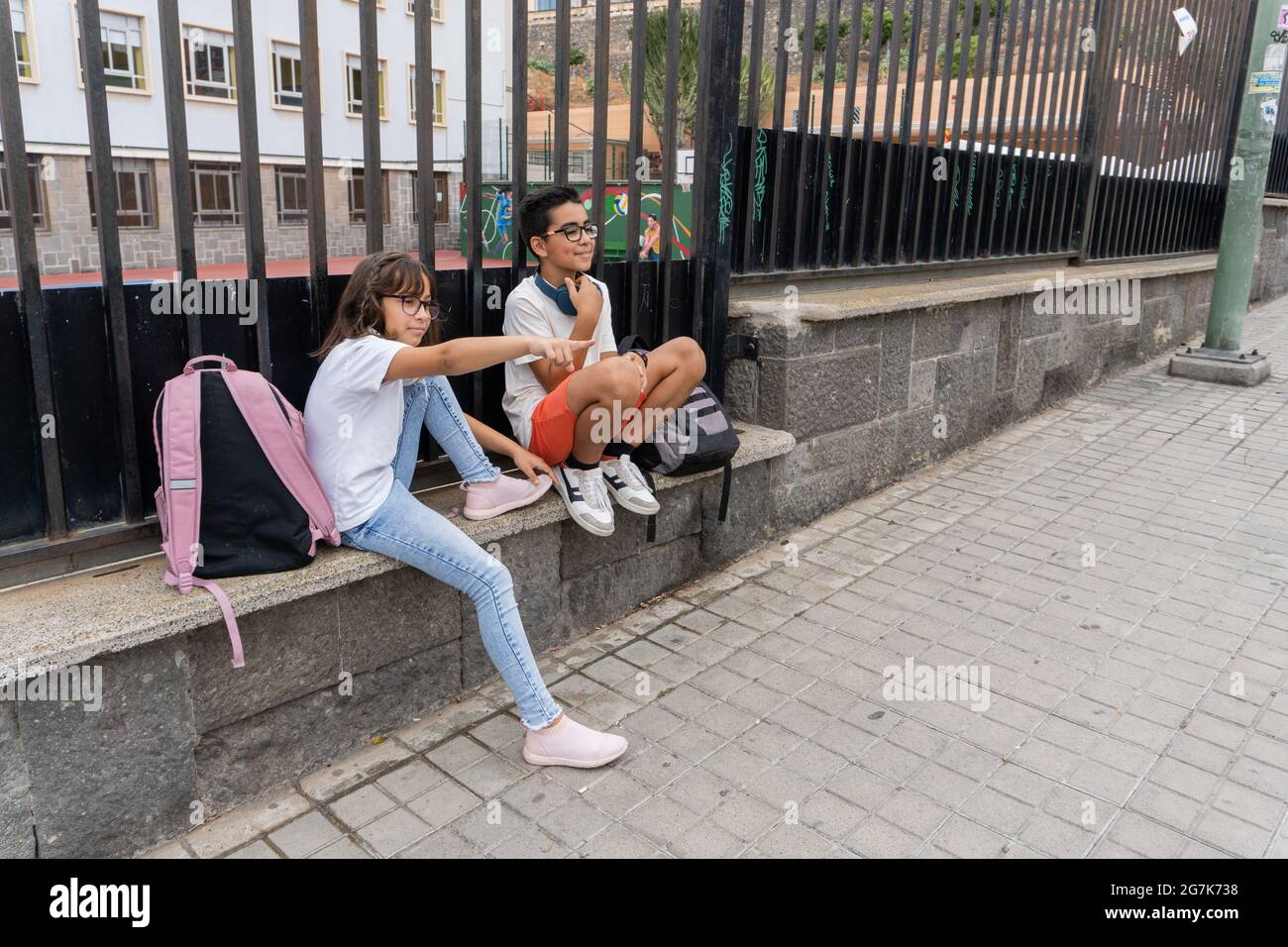 Deux garçons du Caucase rient et parlent à la porte de l'école. Concept de retour à l'école. Banque D'Images