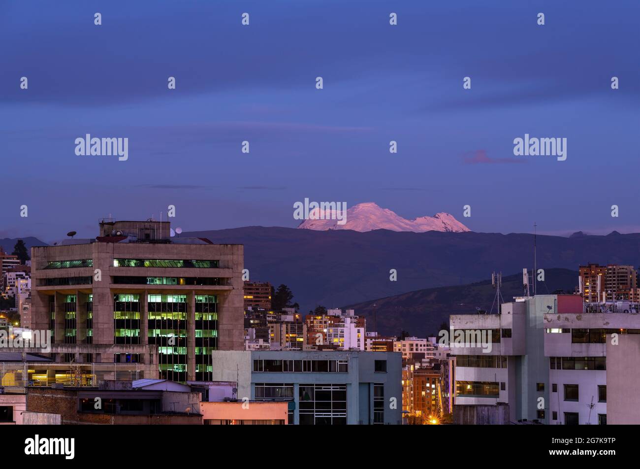 Ville de Quito avec le volcan Antisana pendant l'heure bleue, Equateur. Banque D'Images