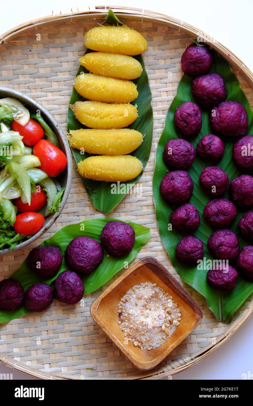 Plateau avec vue sur le dessus de la nourriture végétalienne de la patate douce violette, de la banane bouillie et de la salade avec de la tomate pour un dîner simple, un menu sans viande sera bon pour la santé Banque D'Images