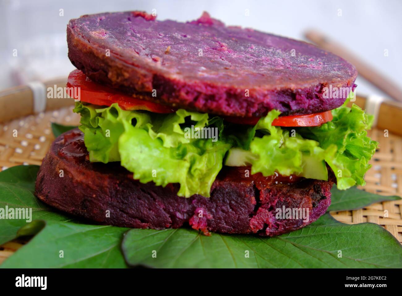 Délicieux hamburger végétalien de patate douce violette à la tomate, salade, nourriture saine pour le petit déjeuner que l'amidon riche, la fibre sur fond blanc Banque D'Images