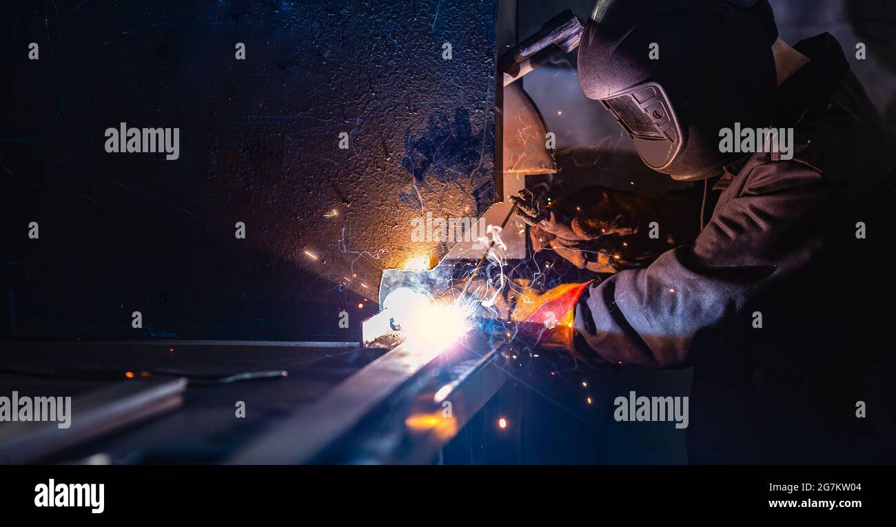 Bannière de l'industrie, soudeur professionnel dans le masque de protection utiliser ériger le fer technique au travail. Banque D'Images