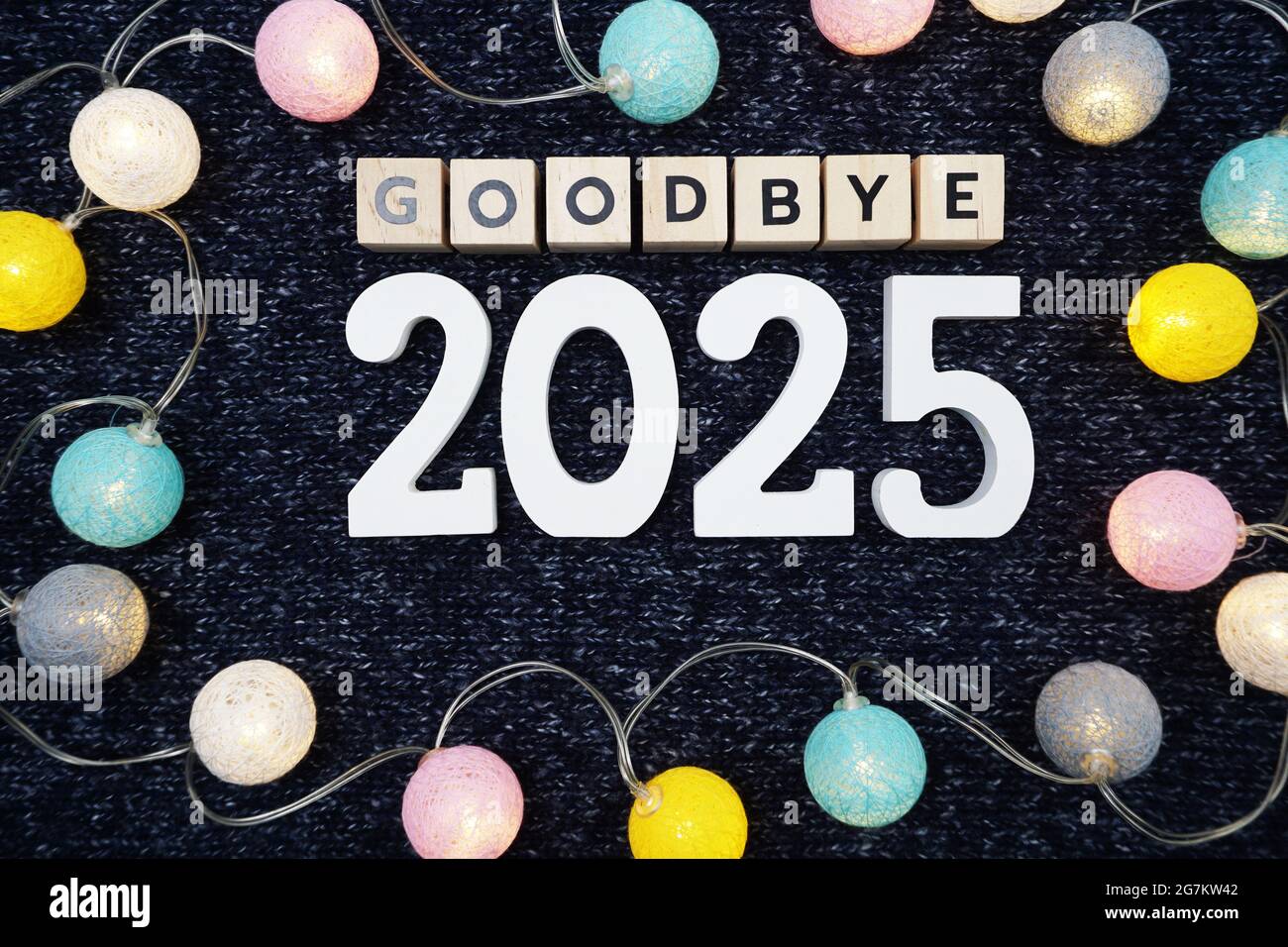Adieu 2025 lettre de l'alphabet décorer avec boule de coton LED sur fond de tissu tricoté bleu Banque D'Images