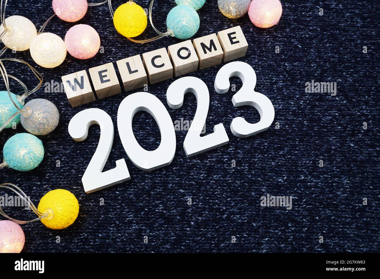 Bienvenue lettre de l'alphabet 2023 avec boule de coton LED sur fond de tissu tricoté bleu Banque D'Images