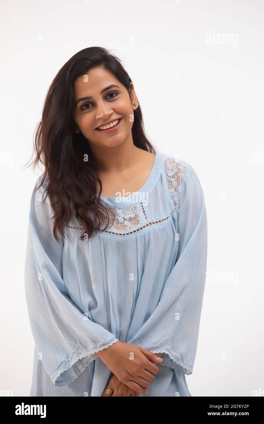 UNE JEUNE FEMME QUI REGARDE L'APPAREIL PHOTO ET QUI SOURIAIT Banque D'Images