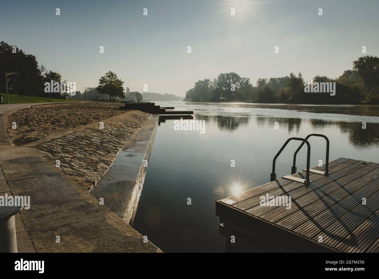 lieu de rencontre ou de rassemblement dans une ville sur une rivière avec une plate-forme en bois et des mains courantes dans un matin ensoleillé Banque D'Images