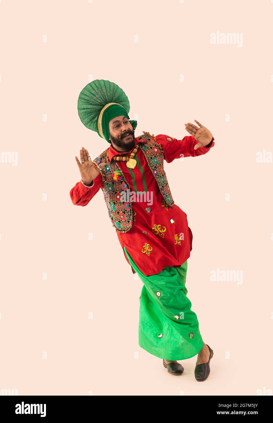 Une danseuse Bhangra démontrant un pas de danse avec les gestes de la main et les jambes croisées. Banque D'Images