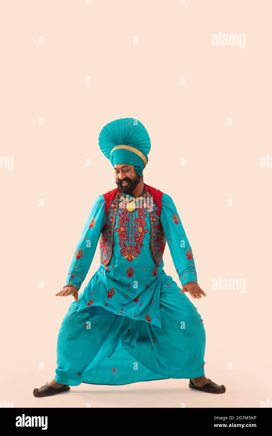 Un danseur de Bhangra regardant vers le bas faisant un pas de danse. Banque D'Images