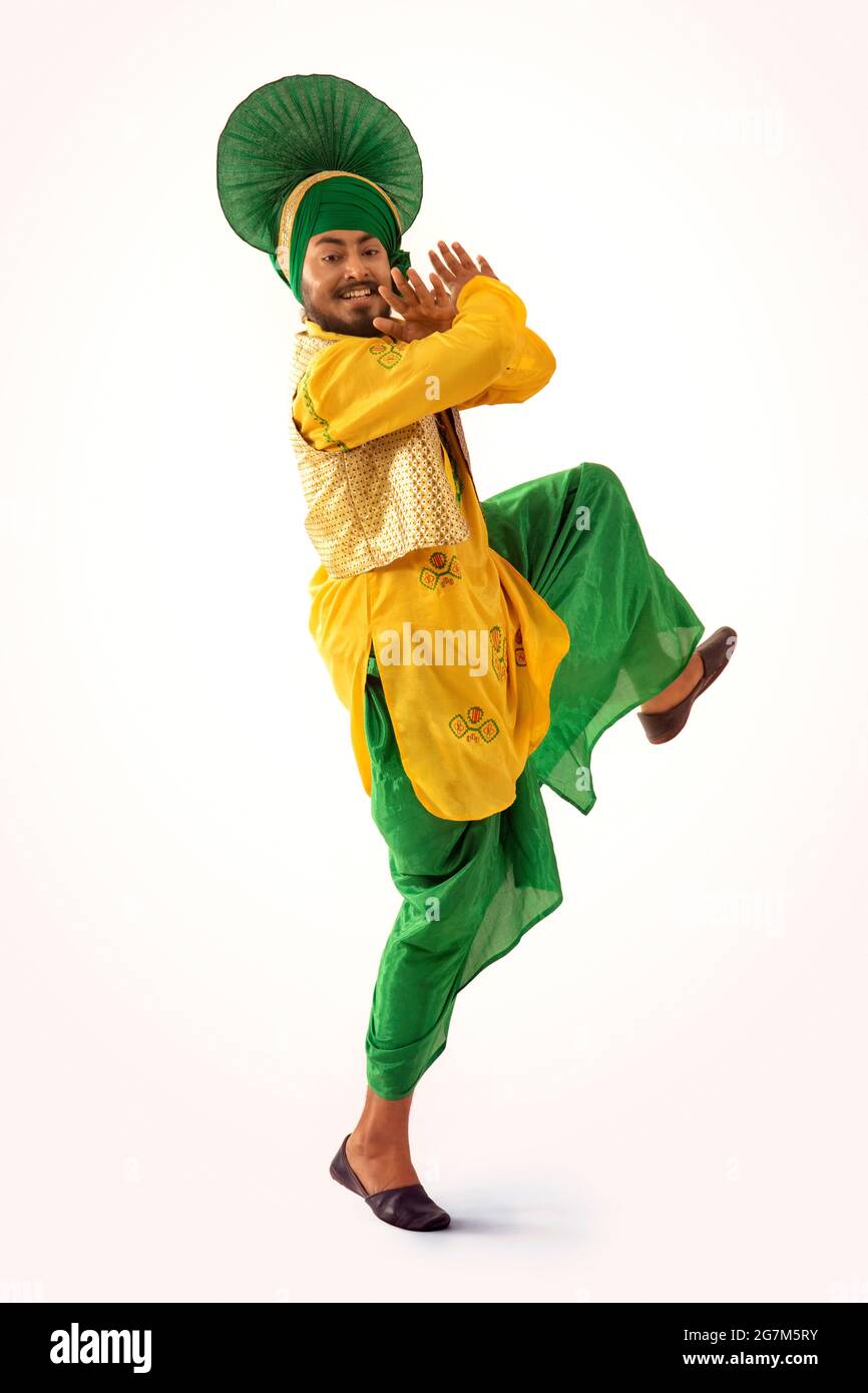 Un danseur Bhangra présentant une étape avec des gestes de main et une jambe rehaussée. Banque D'Images