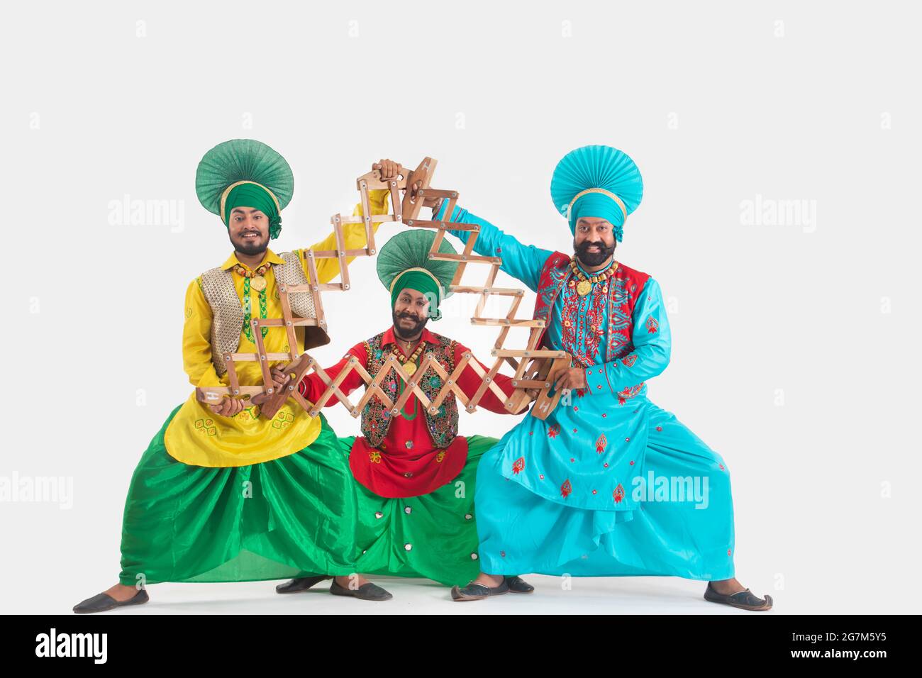 Trois danseurs de Bhangra représentant un pas de danse avec la SAAP. Banque D'Images