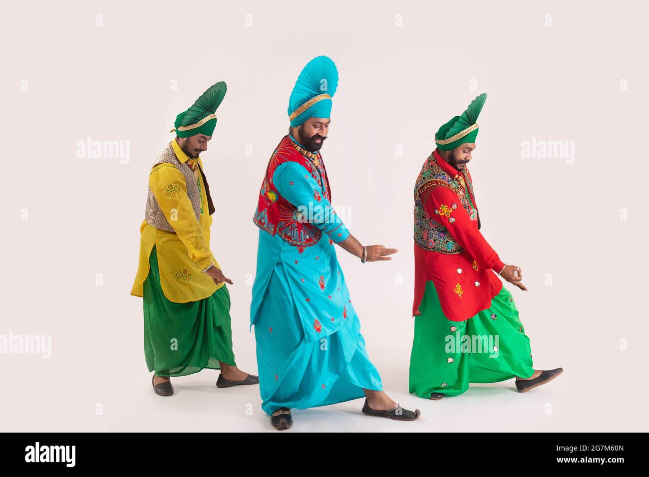 Trois danseurs de Bhangra exécutant un pas de danse avec des gestes de main. Banque D'Images