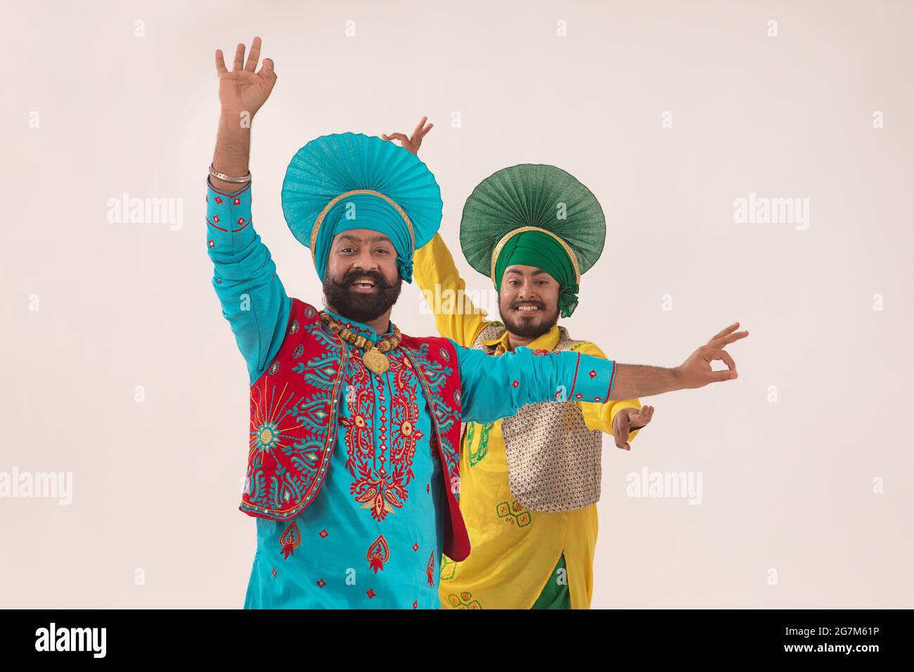 Deux danseurs de Bhangra exécutant un pas de danse avec des gestes de main. Banque D'Images