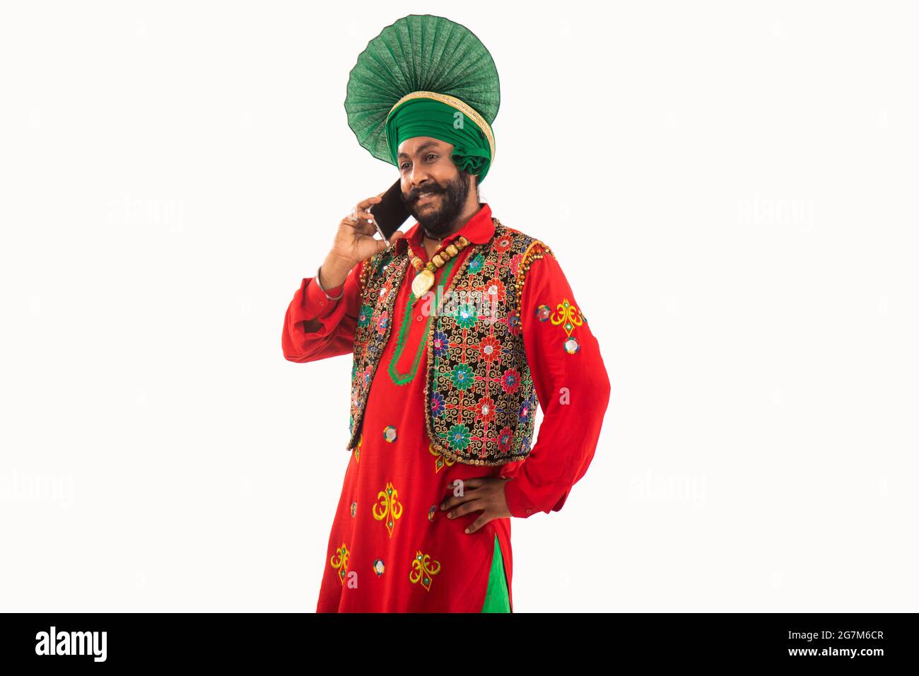 Un homme dans Bhangra Costume parlant par téléphone. Banque D'Images