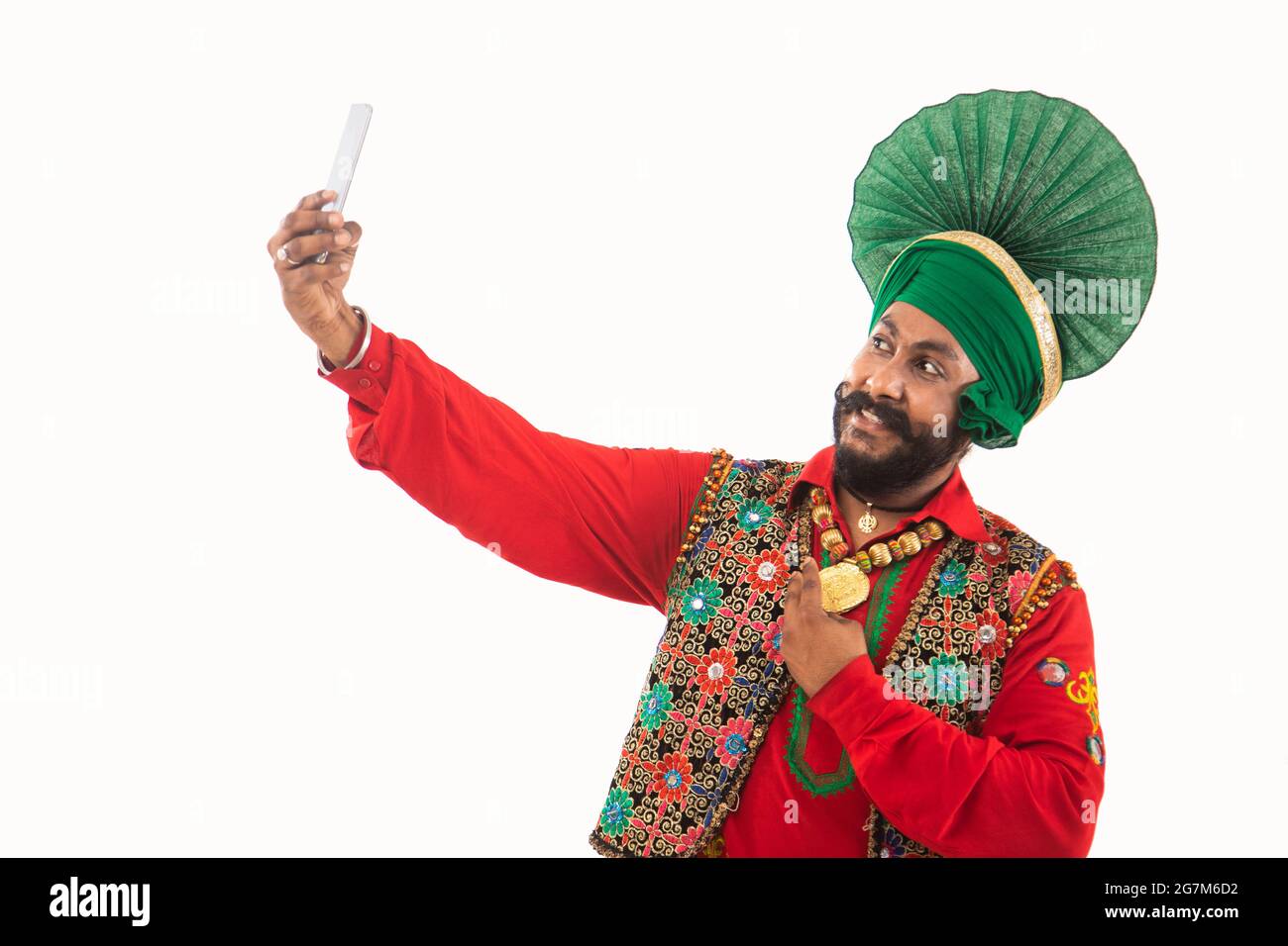 Un homme à Bhangra Costume prenant un selfie dans son téléphone. Banque D'Images