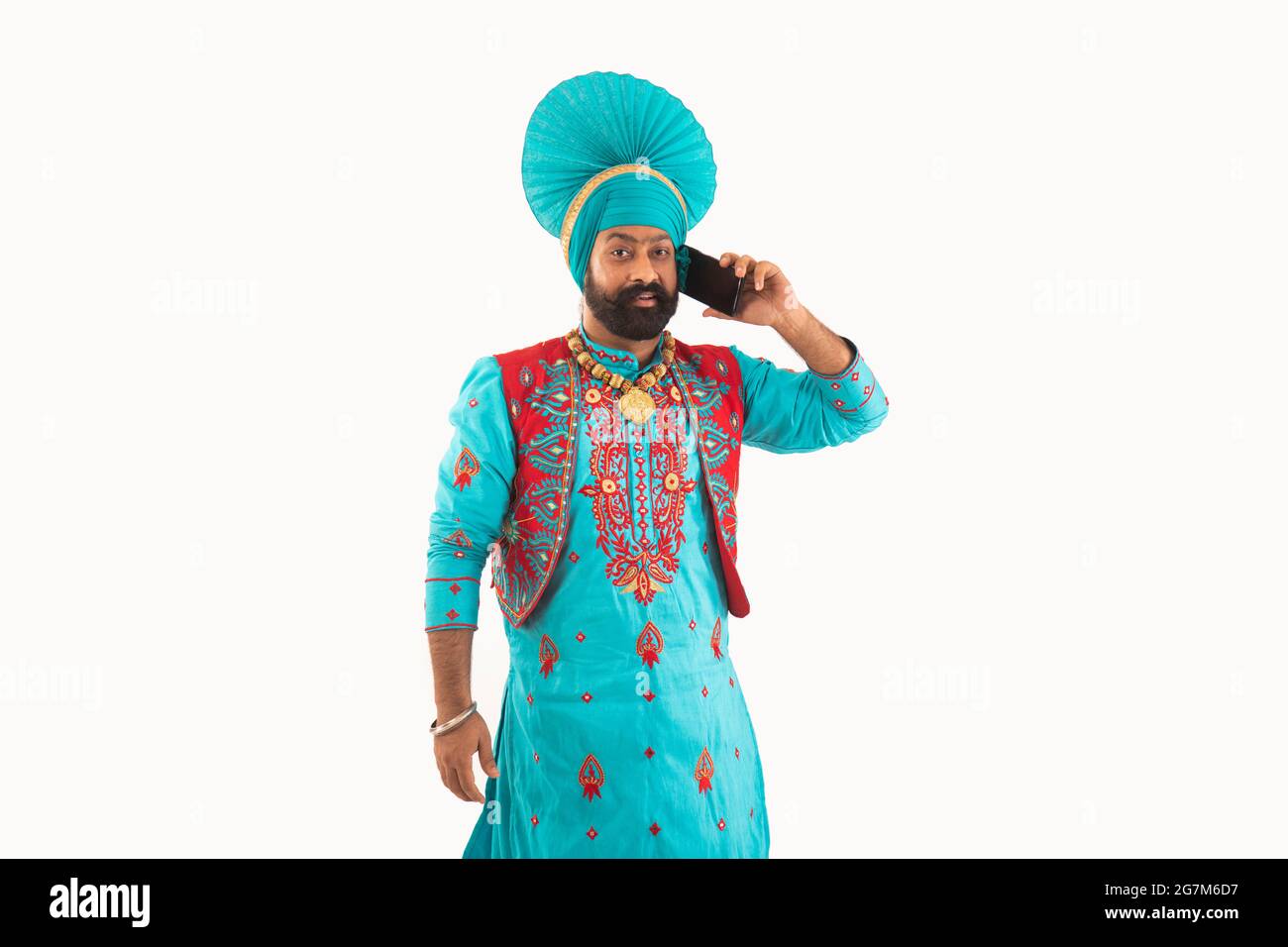 Un homme dans Bhangra Costume parlant par téléphone. Banque D'Images
