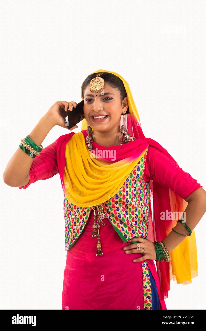 Une femme dans Giddha Costume parlant par téléphone. Banque D'Images