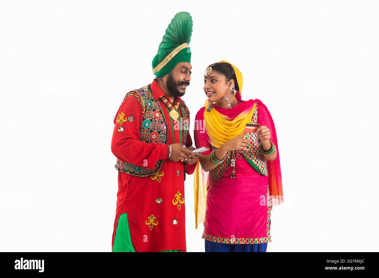 Un Bhangra et UN danseur de Giddha discutant biils ayant un mobile et une carte de crédit en main. Banque D'Images