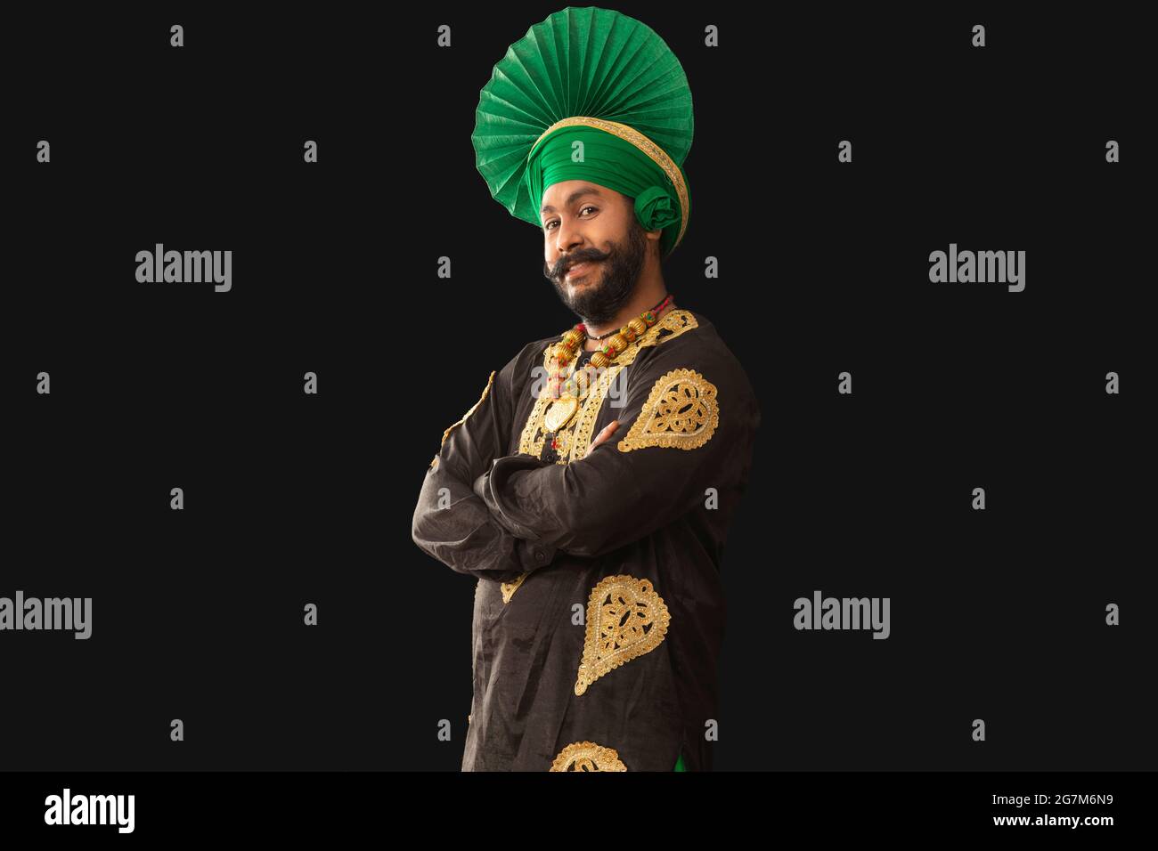 Un homme à Bhangra Costume souriant avec ses mains pliées. Banque D'Images