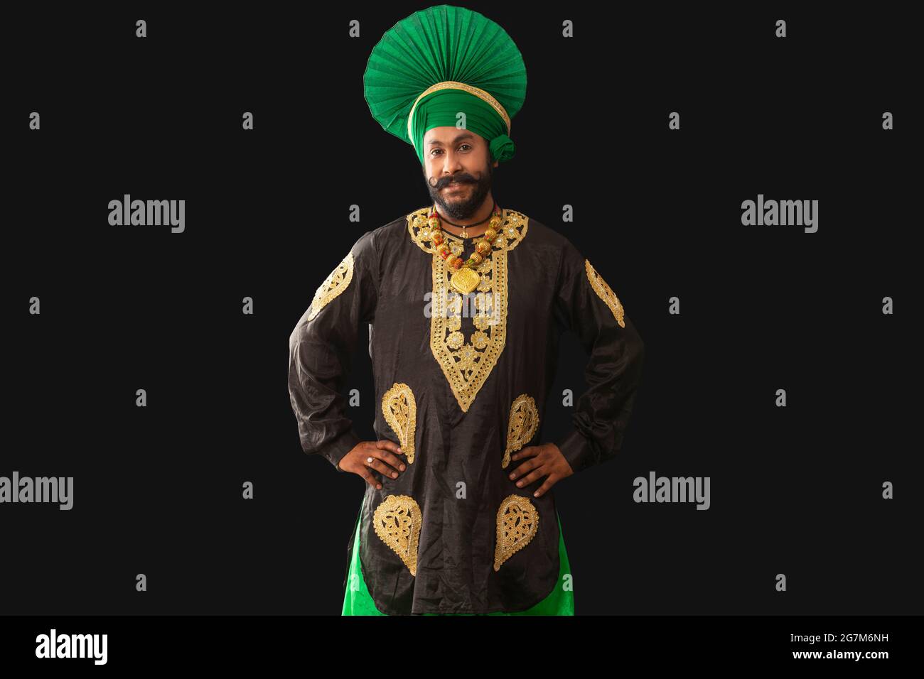 Un homme dans Bhangra Costume debout avec les mains sur sa taille. Banque D'Images