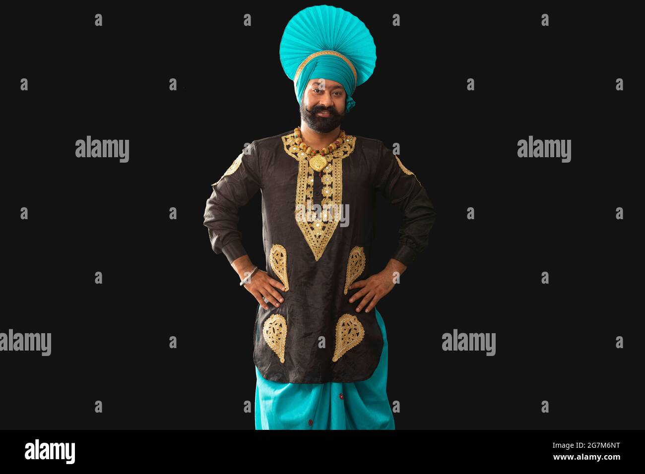 Un homme dans Bhangra Costume debout avec les mains sur sa taille. Banque D'Images