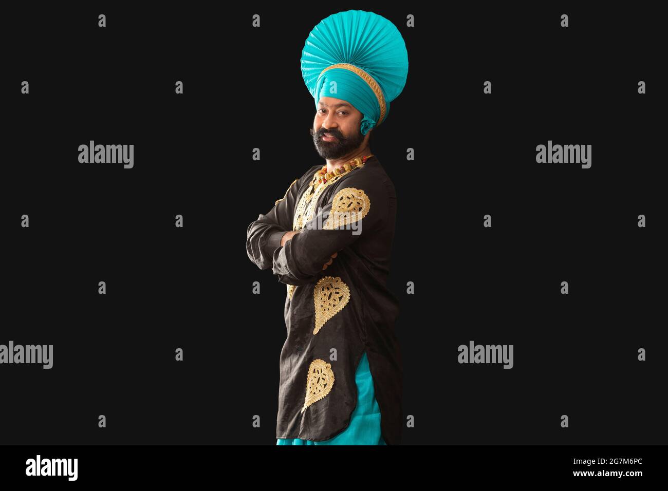 Un homme à Bhangra Costume souriant avec ses mains pliées. Banque D'Images