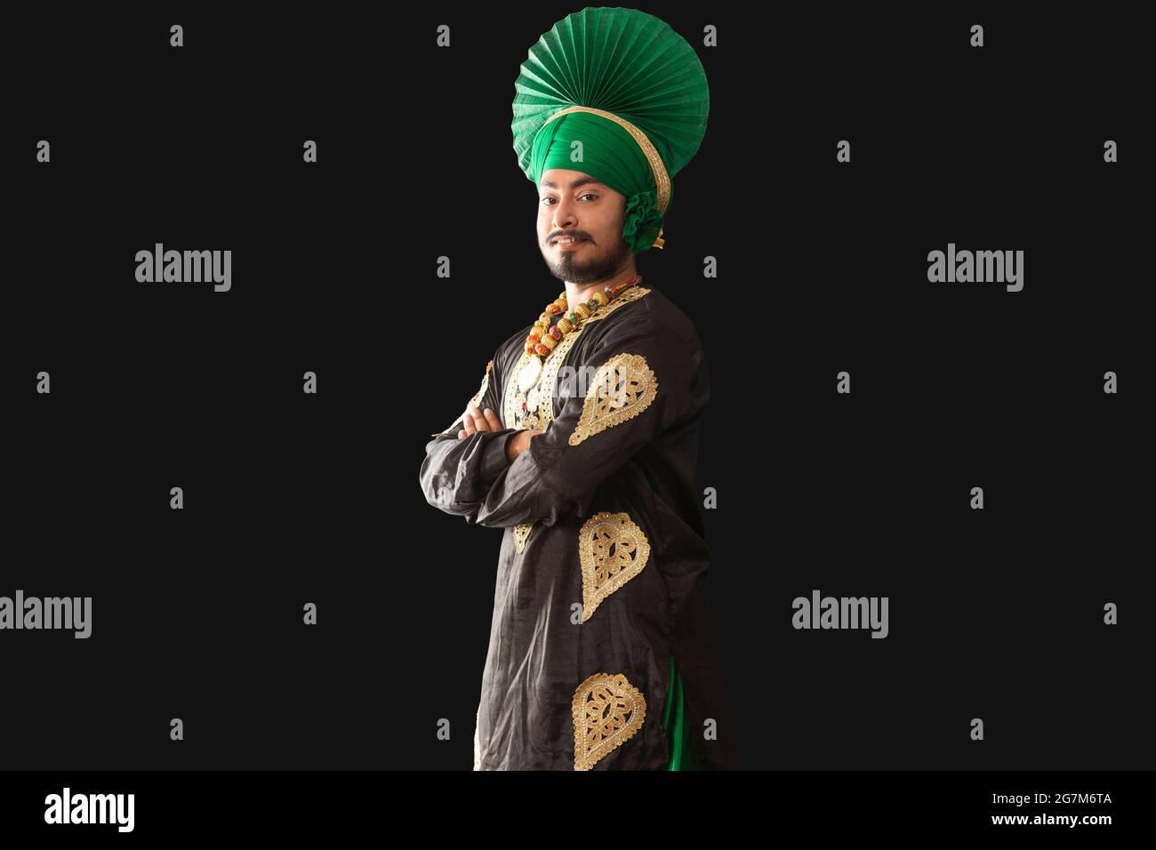Un homme à Bhangra Costume souriant avec ses mains pliées. Banque D'Images