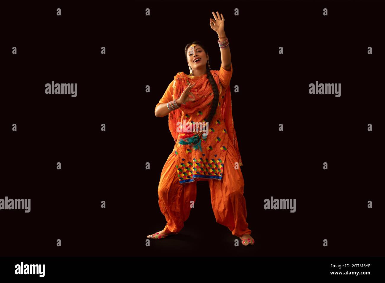 Une femme en costume de Giddha représentant un pas de danse avec des gestes de la main. Banque D'Images