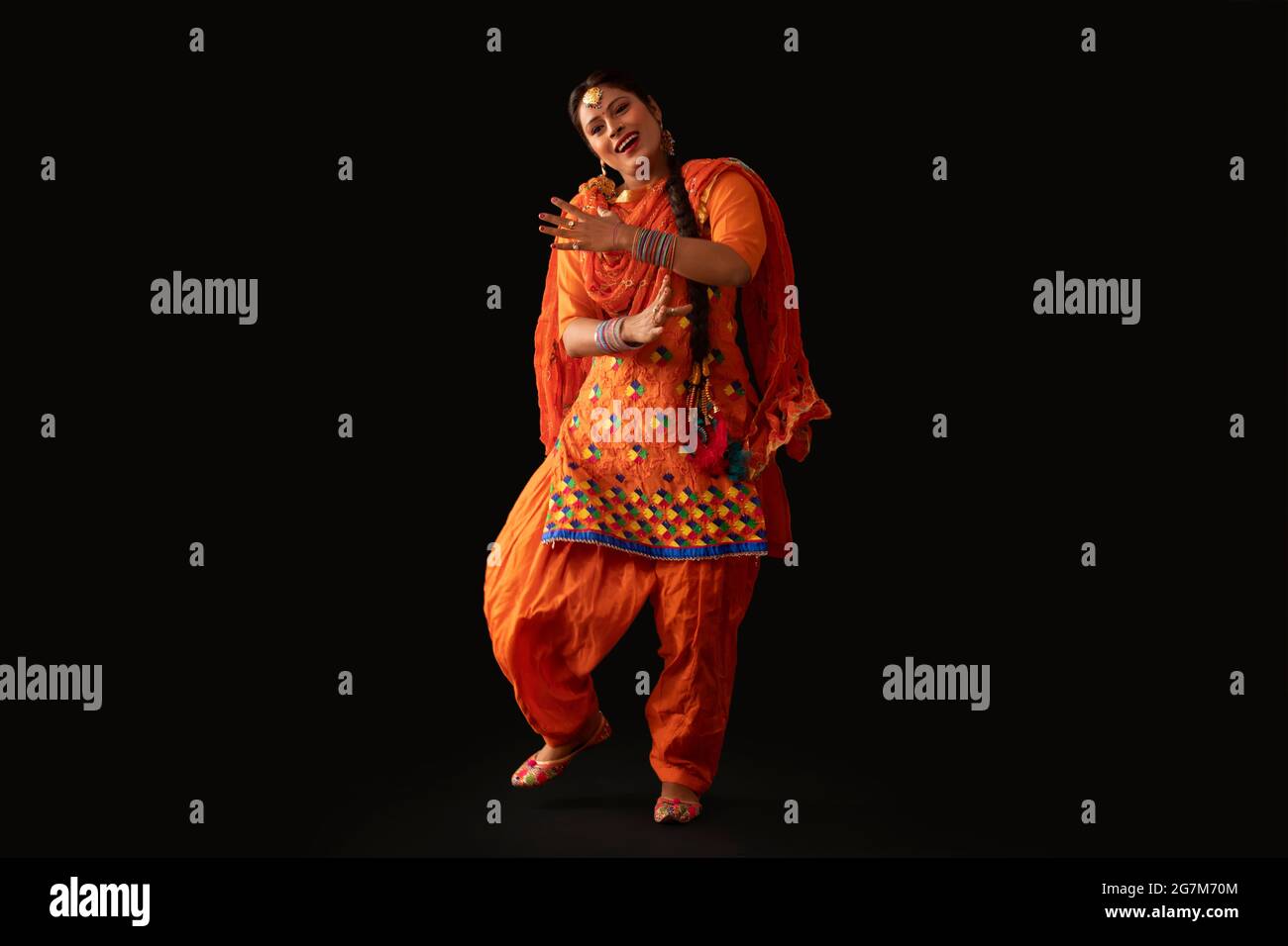 Une femme en costume de Giddha représentant un pas de danse avec des gestes de la main. Banque D'Images