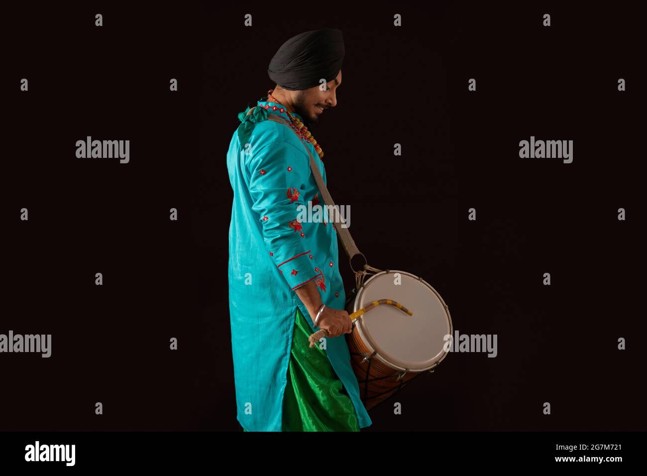 Un danseur de Bhangra battant un Dhol. Banque D'Images