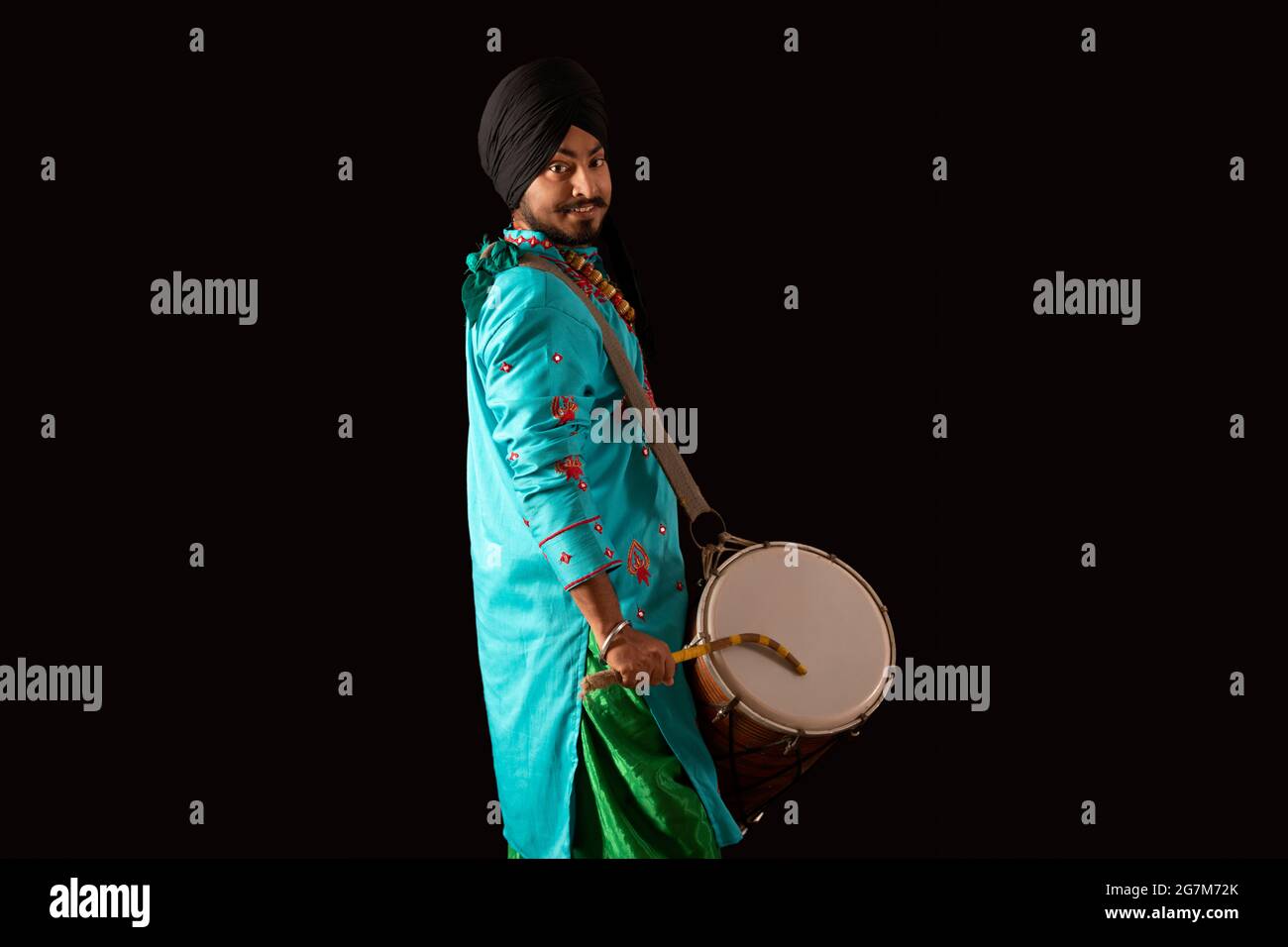 Un danseur de Bhangra battant un Dhol. Banque D'Images