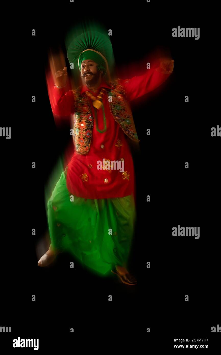 Un danseur de Bhangra exécutant un pas de danse avec des gestes de main Banque D'Images