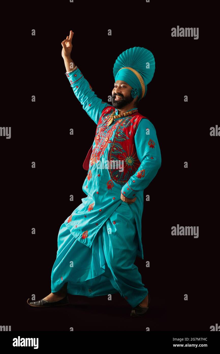 Un danseur de Bhangra exécutant un pas de danse avec des gestes de main. Banque D'Images