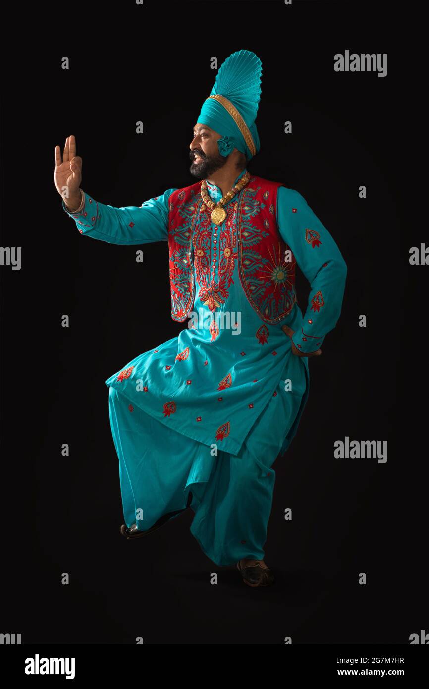 Un danseur de Bhangra exécutant un pas de danse avec des gestes de main. Banque D'Images