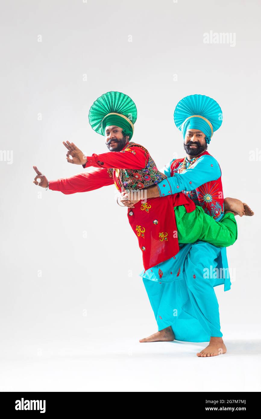 Deux danseurs de Bhangra frappant une étape classique de leur forme de danse. Banque D'Images