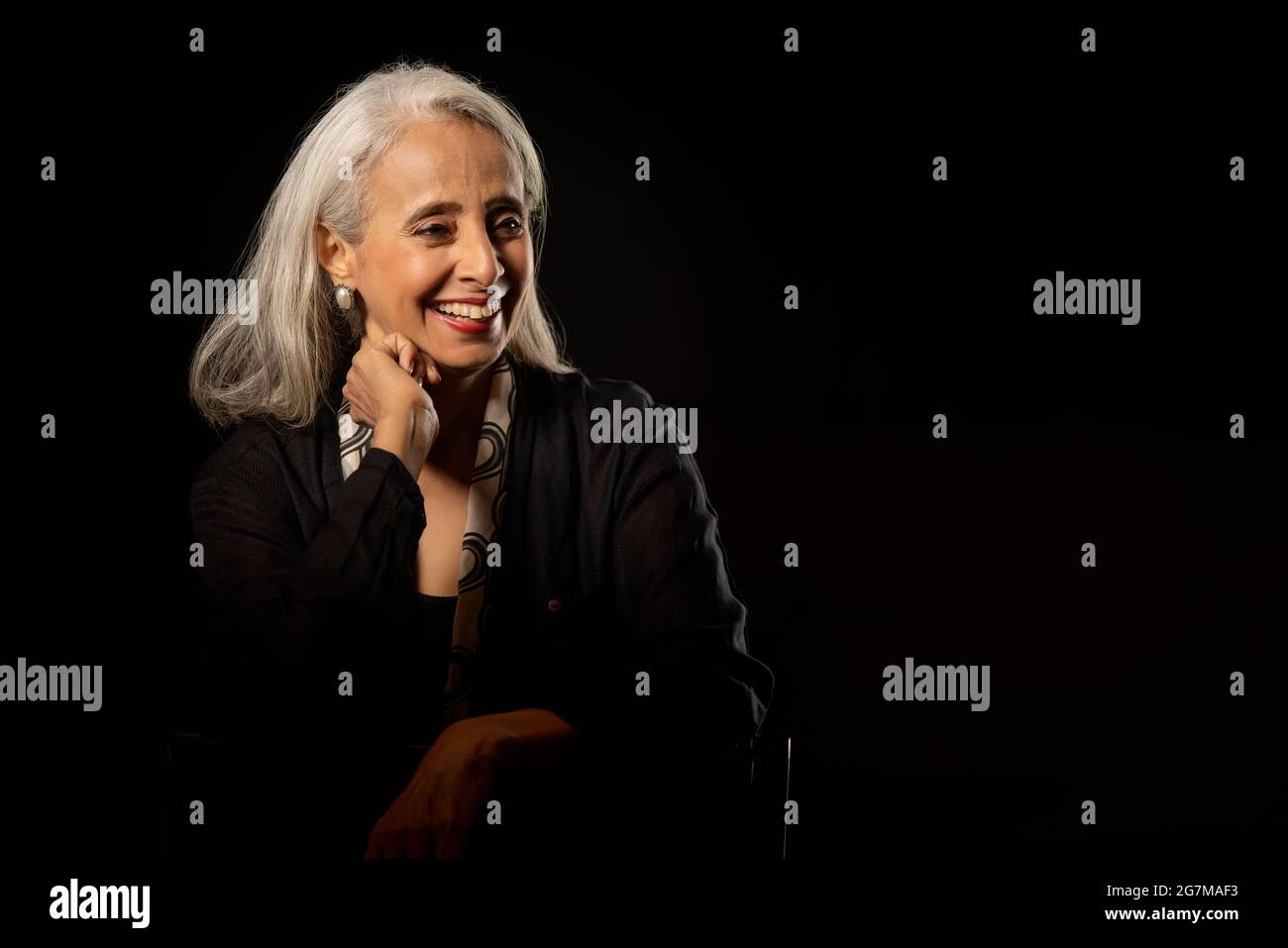 Portrait d'une vieille belle femme souriant regardant ailleurs. Banque D'Images