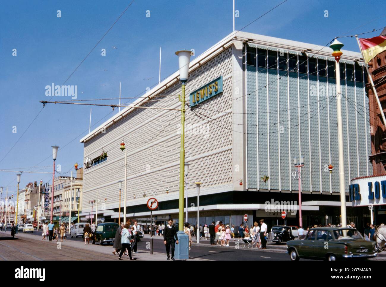 Grand magasin de Lewis sur la promenade, Blackpool, Lancashire, Angleterre, Royaume-Uni c. 1968. Lewis's était une chaîne de grands magasins britanniques qui opéraient de 1856 à 2010. Le premier magasin, qui a ouvert ses portes dans le centre-ville de Liverpool, est devenu le fleuron de la chaîne de magasins opérant sous la bannière de Lewis. La branche moderne de Blackpool se trouvait à côté de la tour de Blackpool et a été ouverte en 1964 sur le site de l'ancienne Alhambra. Il a fermé en 1993 et le bâtiment a été dépouillé avant d'être incliné en brique. Cette image provient d'une ancienne transparence couleur 35 mm amateur, une photographie vintage des années 1960. Banque D'Images