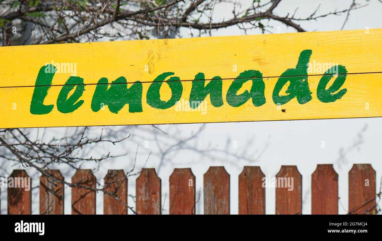 Limonade verte texte manuscrit sur panneau en bois jaune, à côté d'une clôture. Boissons fraîches d'été, boissons. Banque D'Images