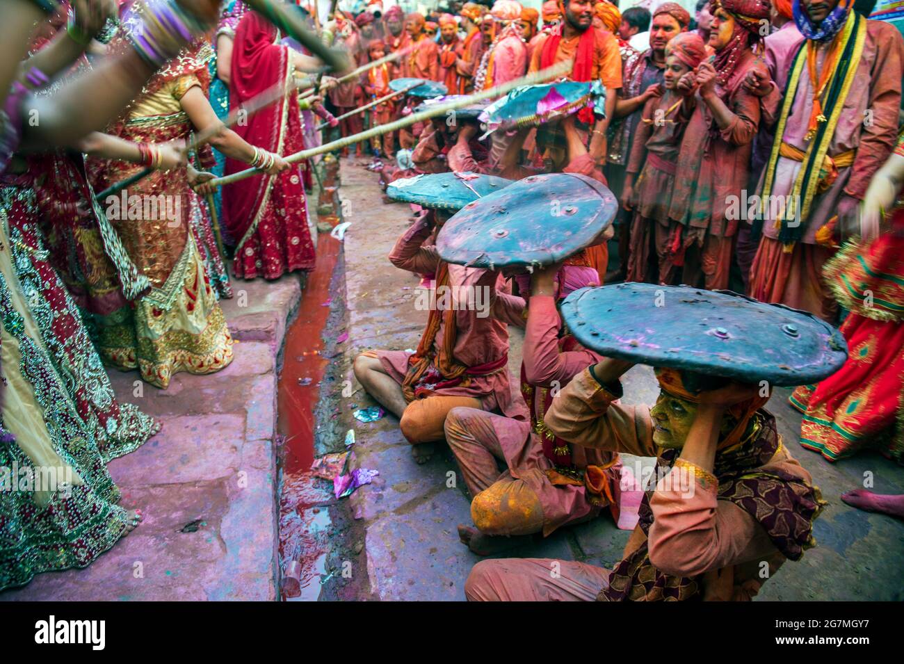 Les hommes de Barsana raid la ville voisine de Nandgaon et sont battus par les femmes de Nandgaon avec de grands bâtons et étalé avec des poudres de couleur Holi Banque D'Images