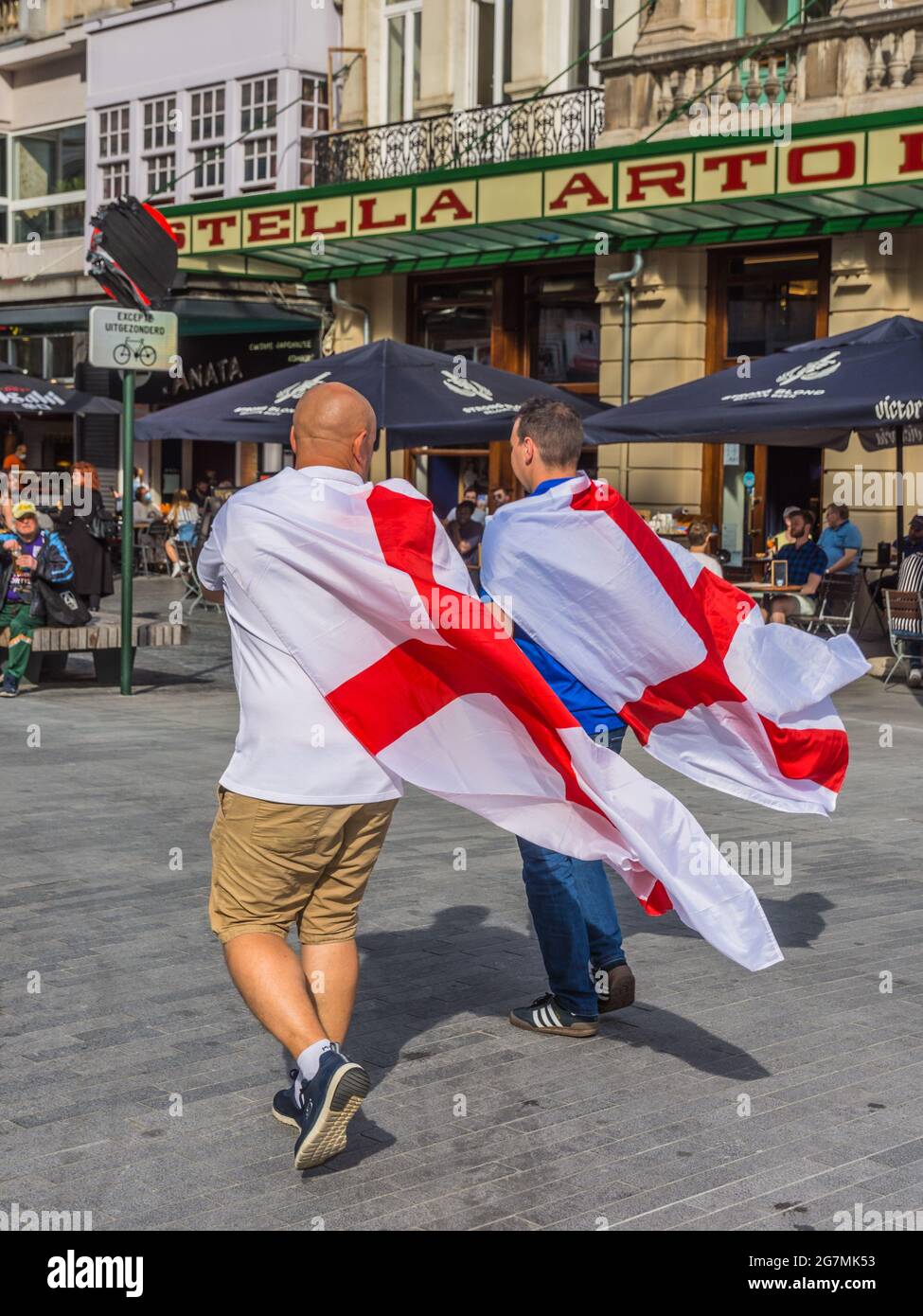 Deux supporters britanniques de l'Euro 2021 traversent le centre-ville de Bruxelles avec le drapeau de St George au-dessus des épaules Banque D'Images