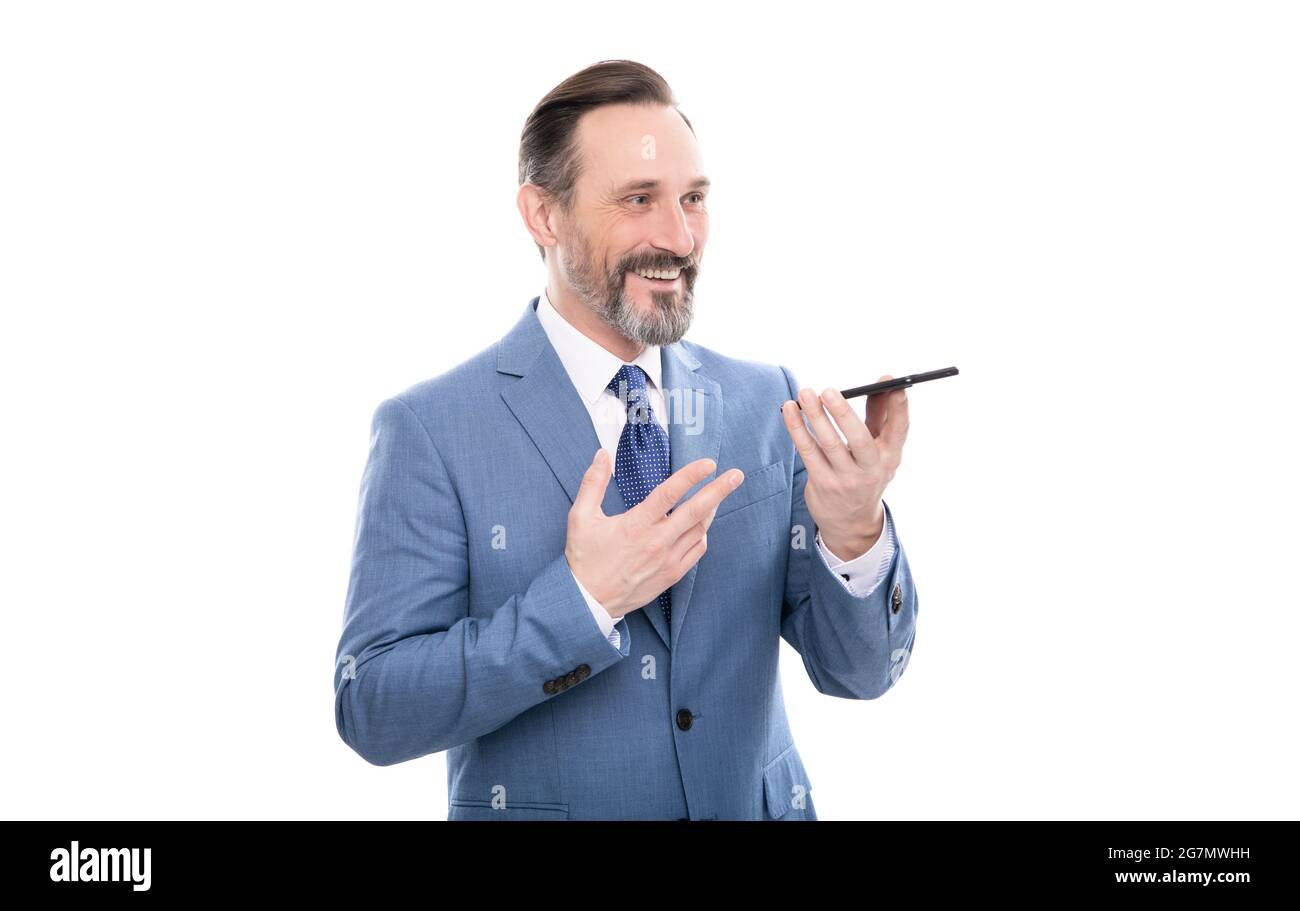 un homme d'affaires souriant et souriant en costume envoie un message vocal sur un téléphone isolé d'un message vocal blanc. Banque D'Images