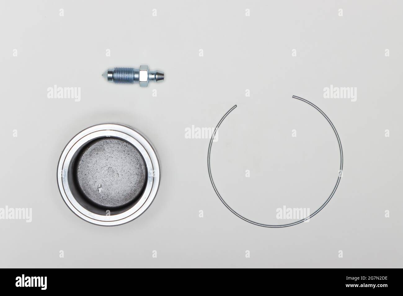 Kit de réparation d'étrier, piston-plongeur métallique, anneau de retenue et raccord. Jeu de pièces de rechange pour la réparation des freins de voiture. Détails sur fond blanc, espace de copie disponible. 4K UHD. Banque D'Images