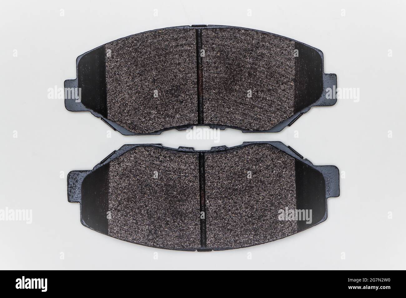 Deux plaquettes de frein sur une surface plane. Jeu de pièces de rechange pour la réparation des freins de voiture. Détails sur fond blanc, espace de copie disponible. 4K UHD. Banque D'Images