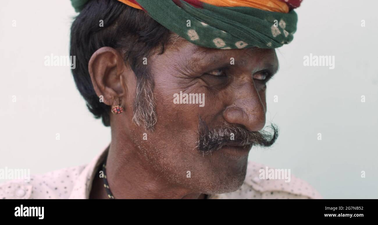 Portrait d'un vieil homme indien avec boucles d'oreilles et coiffures de  moustache sur fond blanc Photo Stock - Alamy