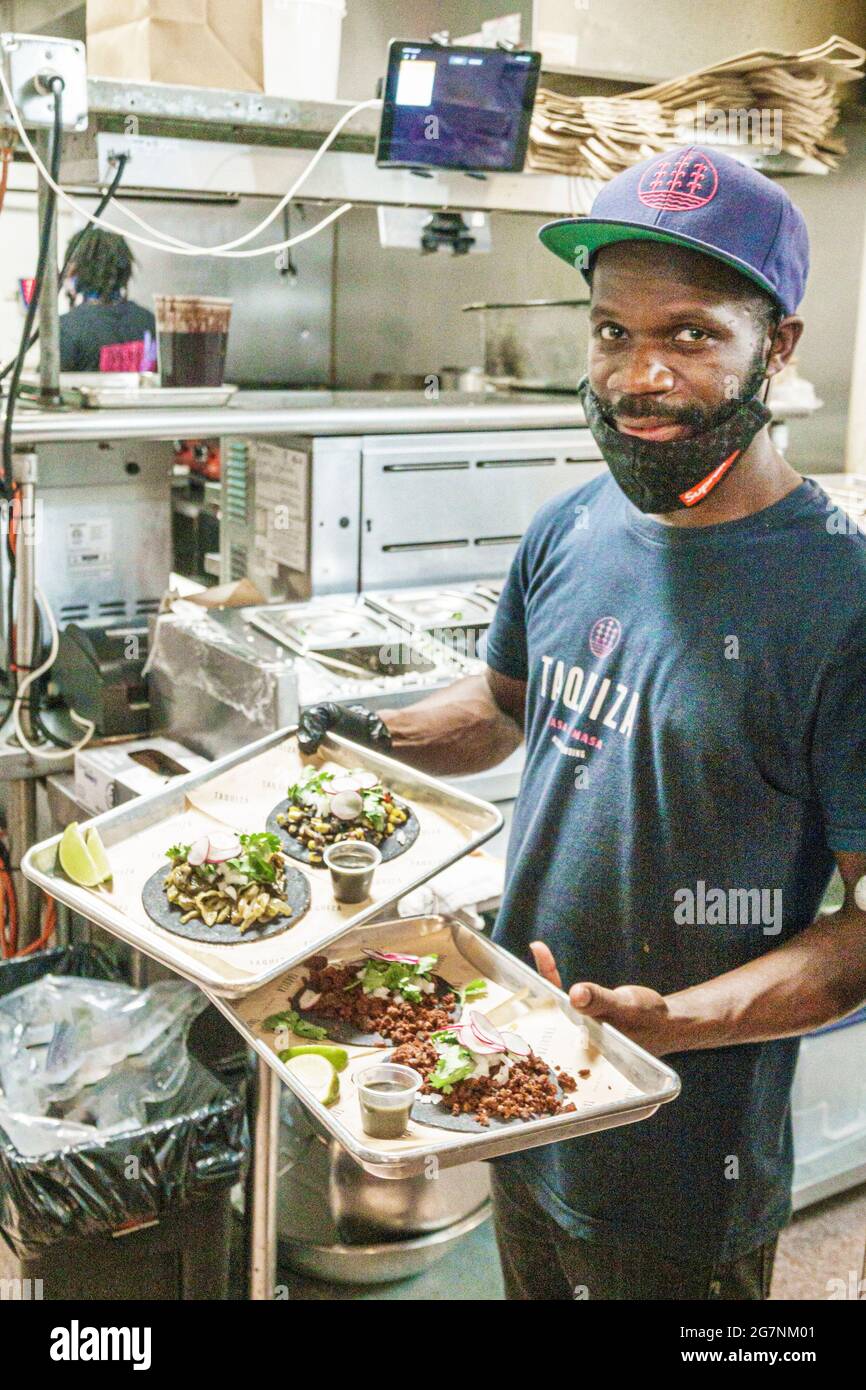 Miami Beach Florida Taquiza personnel du restaurant cuisinier Black man tient des plateaux repas tacos Banque D'Images