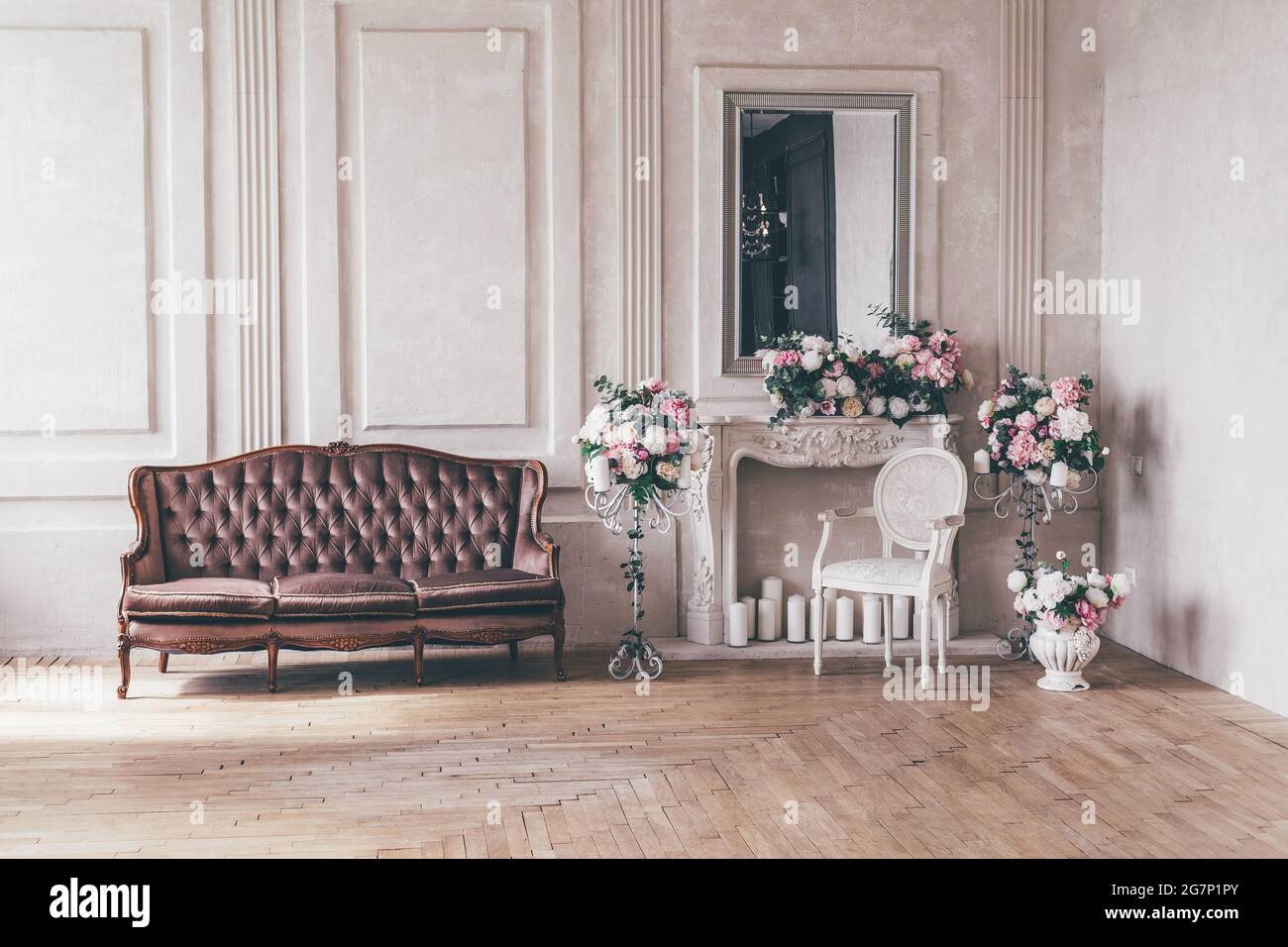 Canapé d'intérieur vintage avec un vase de fleurs dans un style chic et chic. Banque D'Images