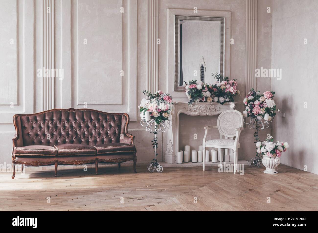 Canapé d'intérieur vintage avec un vase de fleurs dans un style chic et chic. Banque D'Images