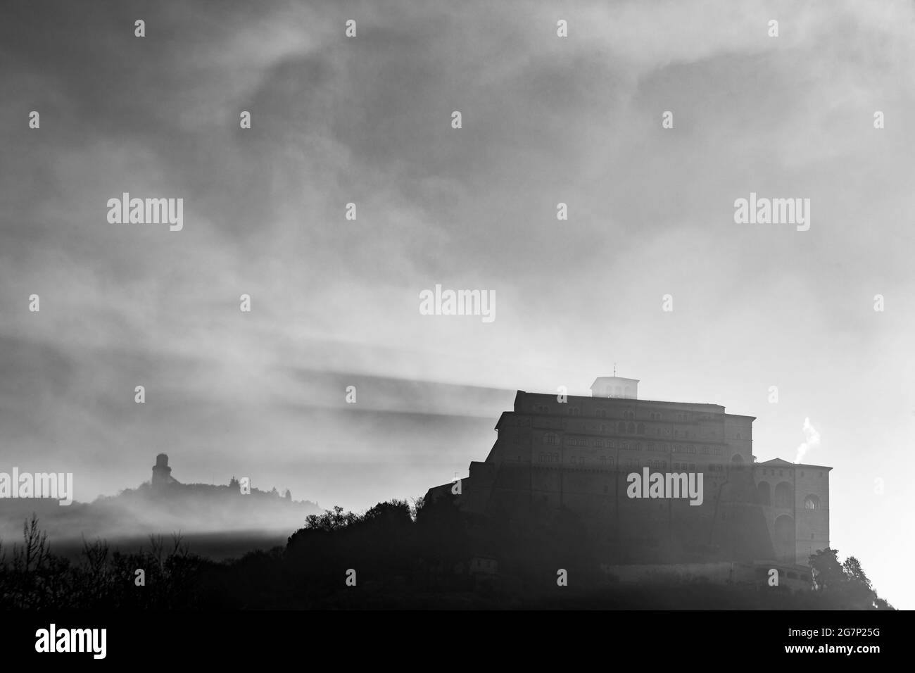 L'église Saint François d'Assise, en Ombrie, en Italie, projette des ombres dans la brume. Banque D'Images