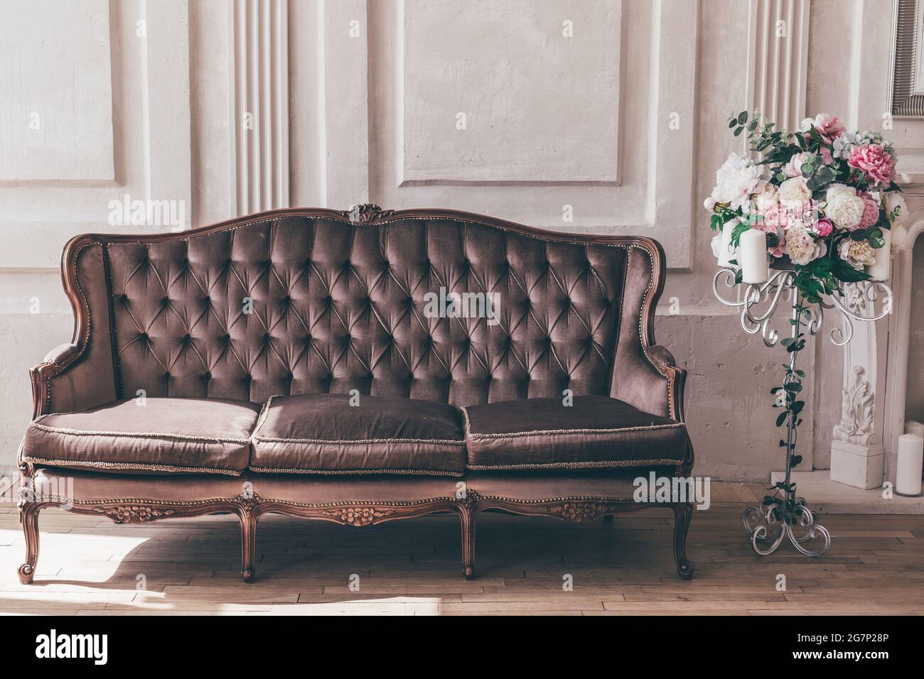 Canapé et support intérieur vintage avec fleurs dans un style chic et chic. Banque D'Images