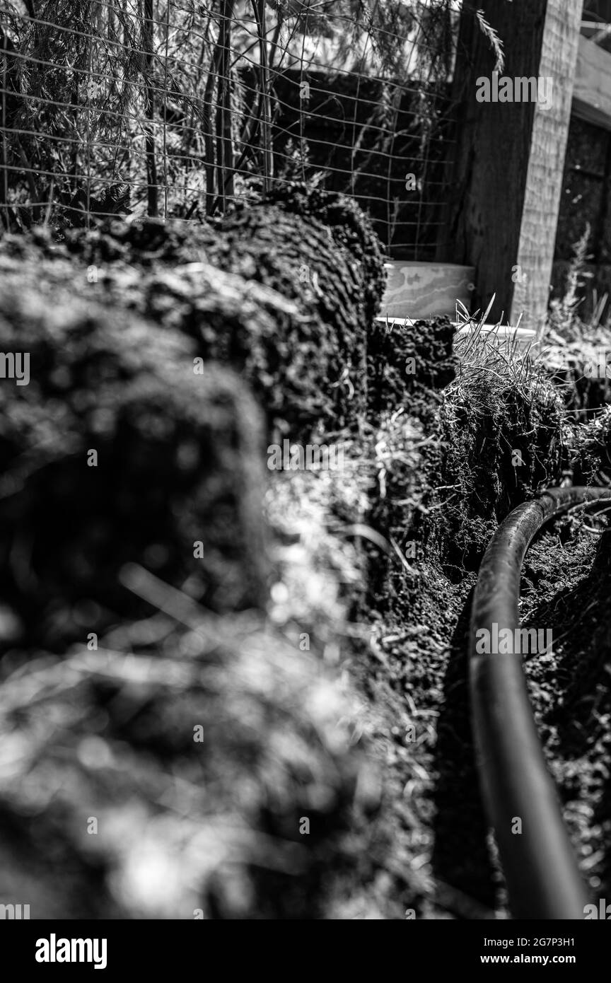 Concentrez-vous sur une ligne d'eau en plastique noire de 1 pouce posée dans une tranchée peu profonde Banque D'Images