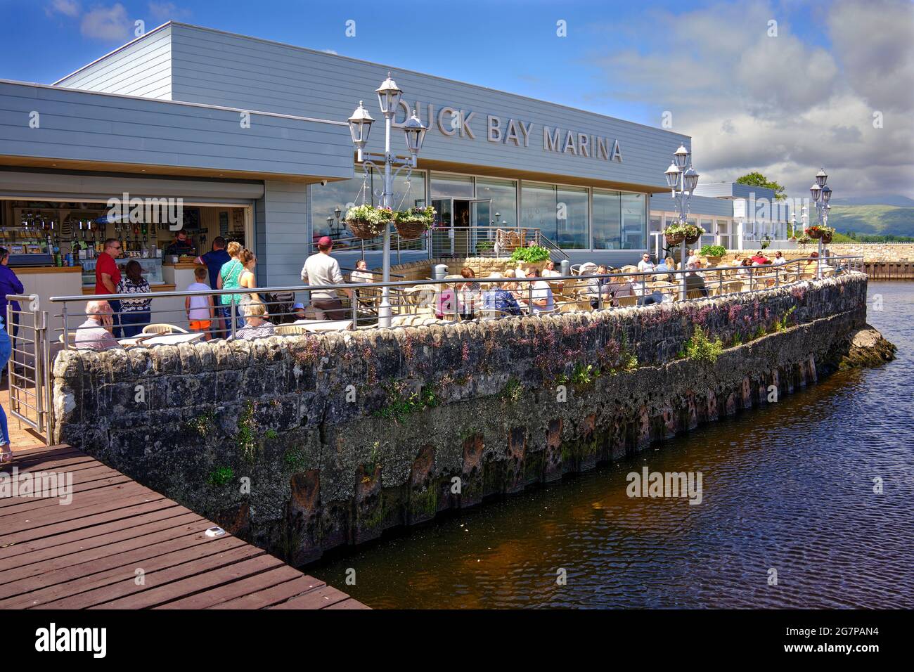 Les gens qui profitent du soleil sur les rives du Loch Lomond au café de Duck Bay Marina Banque D'Images